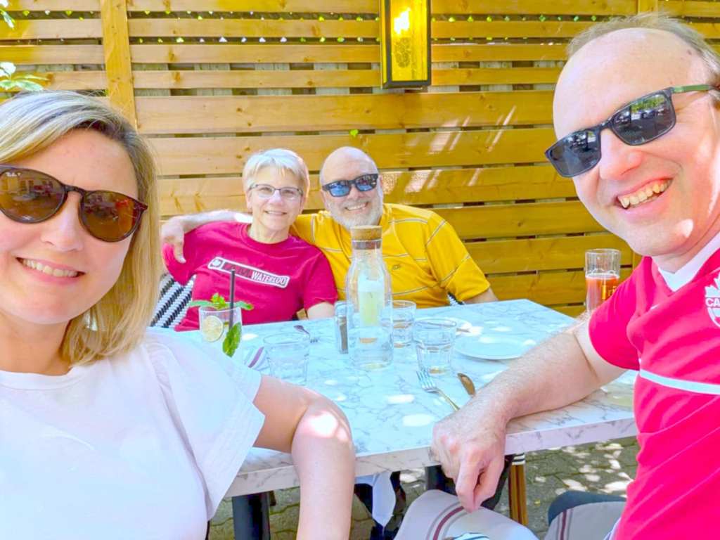 Four people on patio table. Both women look blonde.