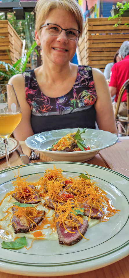 Woman with golden brown hair in front of plates of appetizers.